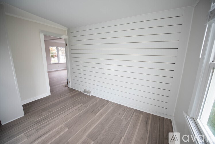 A room with wooden flooring and white walls.