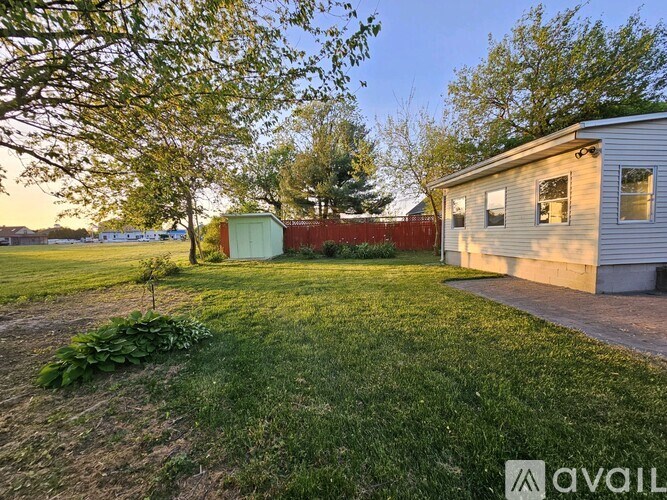 A backyard with a shed and a house.