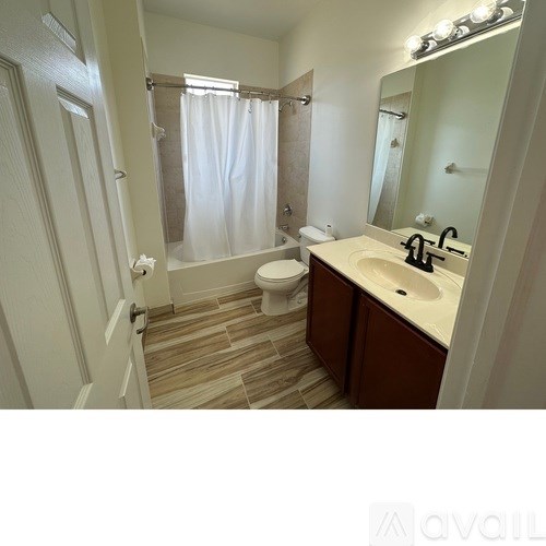 A bathroom with a toilet, sink, and shower.