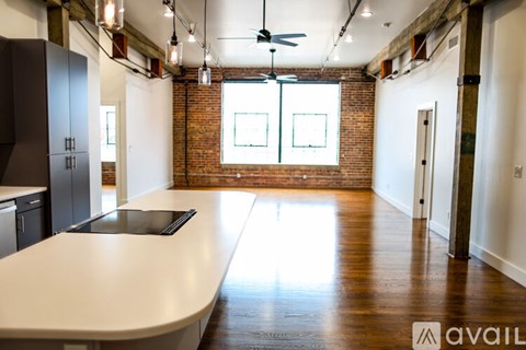 A kitchen with a long counter and a fan.
