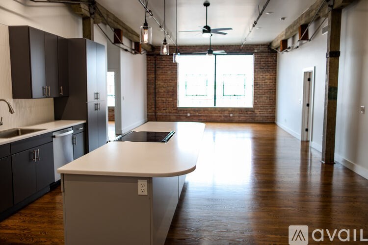A kitchen with a white countertop and wooden floors.