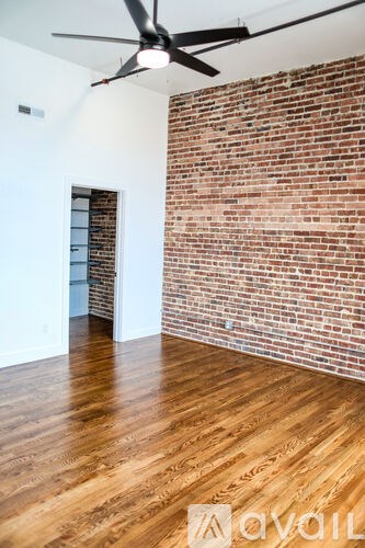 A room with a brick wall and wooden flooring.