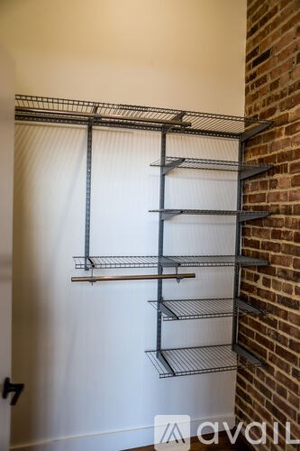 A metal shelving unit is mounted on a white wall.