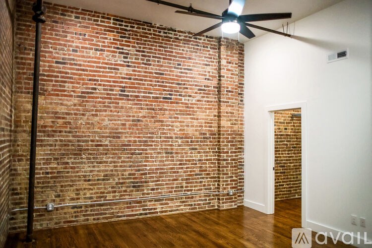A room with a brick wall and a ceiling fan.