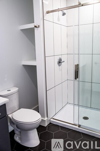 A white toilet sits next to a walk-in shower.