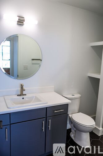 A bathroom with a sink, toilet and mirror.