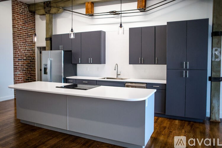 A kitchen with a white countertop and dark grey cabinets.