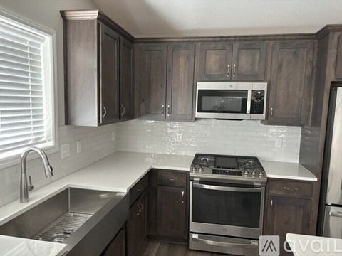 A kitchen with dark wood cabinets and stainless steel appliances.