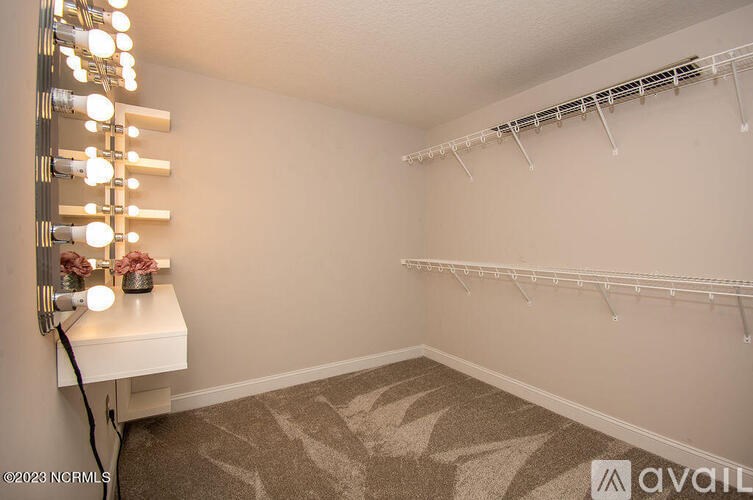A room with a vanity table and a mirror with lights on it.