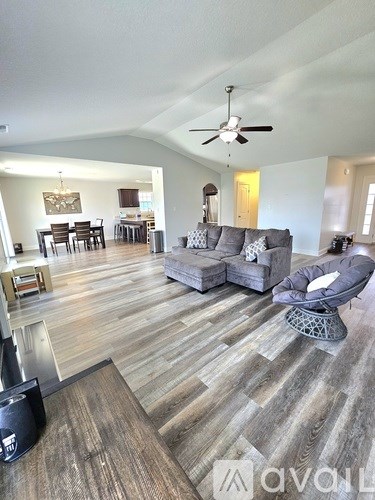 A living room with a grey couch and a black speaker.