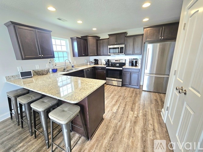 A kitchen with a granite countertop and stainless steel appliances.