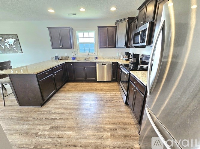 A kitchen with dark wood cabinets and stainless steel appliances.