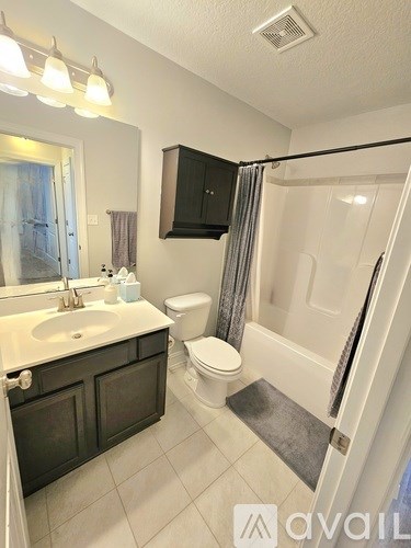A bathroom with a sink, toilet, and bathtub.