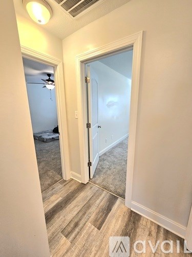 A room with a door and a fan on the wall.