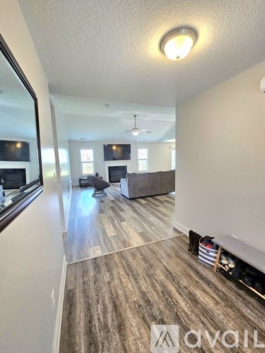 A room with a wooden floor and a mirror on the wall.