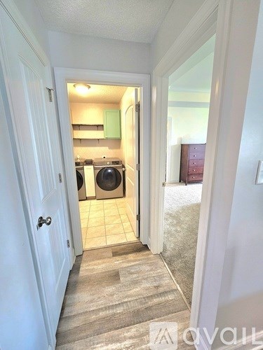 A hallway with a doorway leading to a kitchen.