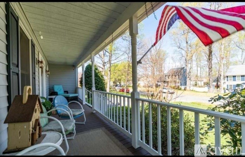A porch with a flag and a birdhouse.