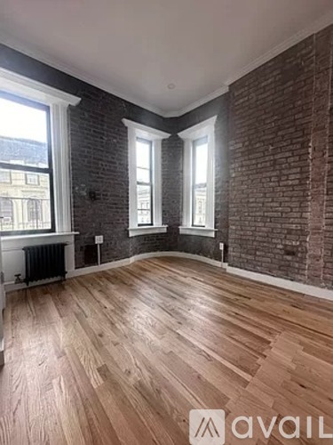 A room with wooden floors and brick walls.