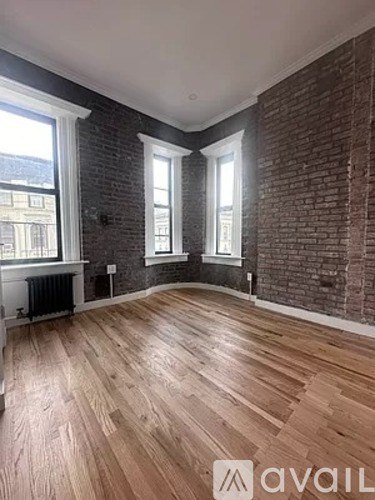 A room with wooden floors and brick walls.