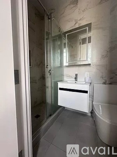 A bathroom with a sink, mirror, and glass shower door.