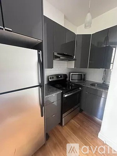 A kitchen with a refrigerator, stove, and microwave.