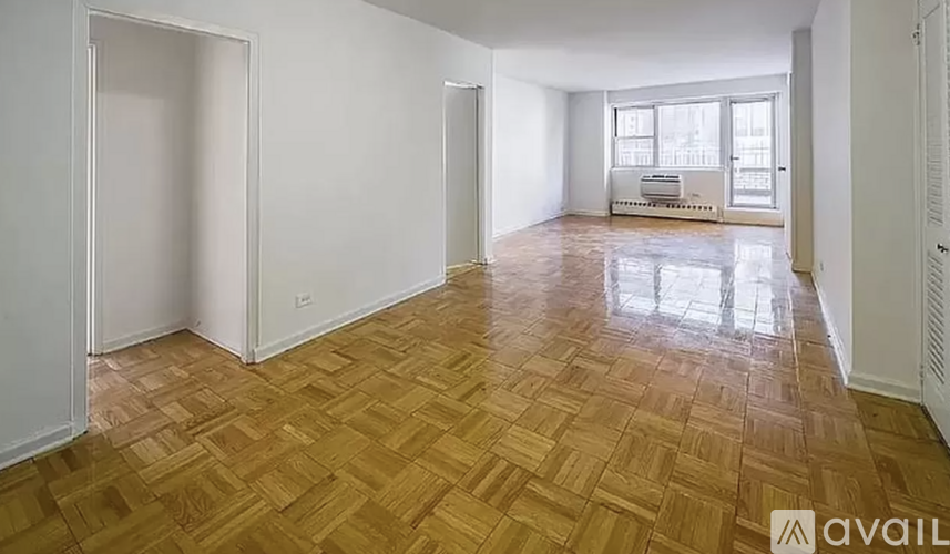 A room with wooden flooring and white walls is available for rent.