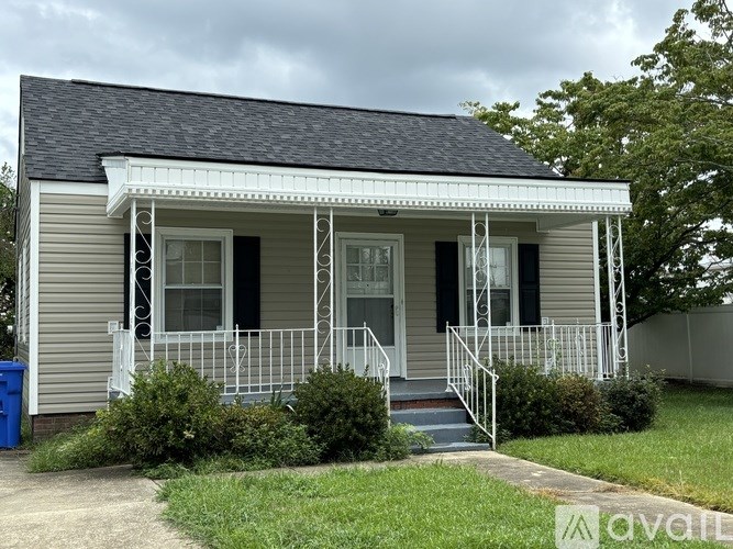 A small house with a porch and a white railing.