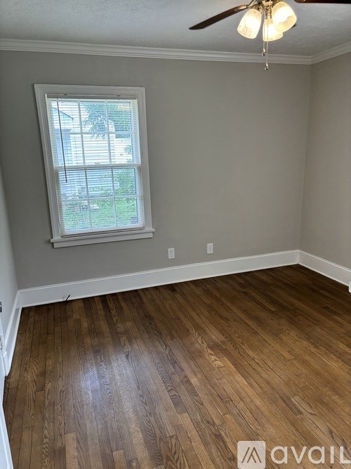 A room with a window and a ceiling fan.