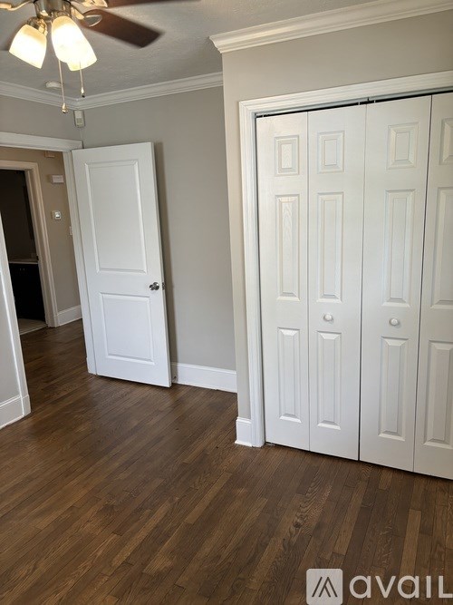A room with a ceiling fan and wooden floors.