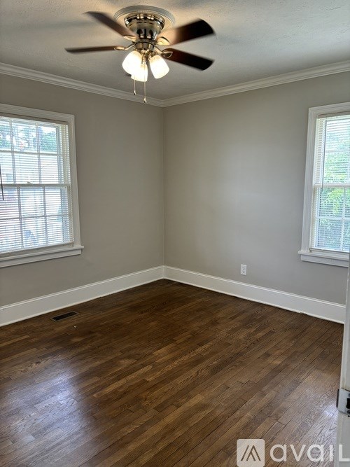 A room with wooden flooring and a ceiling fan.
