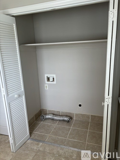 A room with a white door and a white wall with a switch and a light switch.
