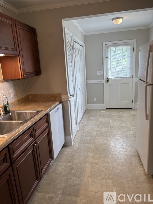 A kitchen with brown cabinets and a white refrigerator.