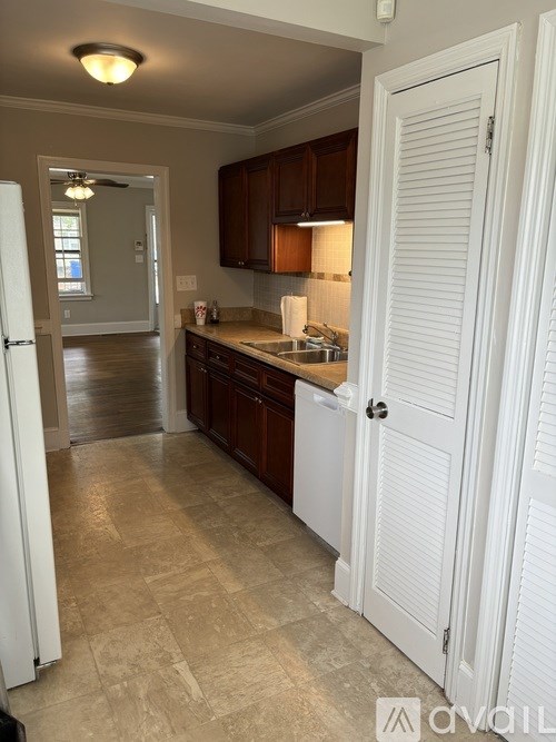 A kitchen with a white refrigerator and wooden cabinets.