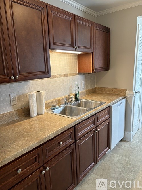 A kitchen with brown cabinets and a beige countertop.