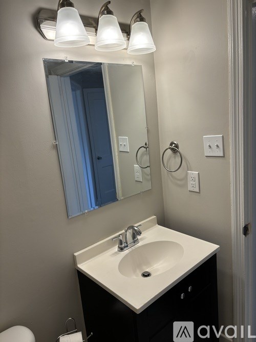 A bathroom with a sink, mirror, and lights.