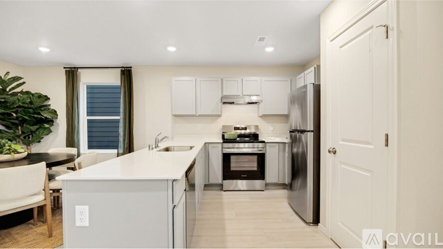 A modern kitchen with a refrigerator, sink, and oven.