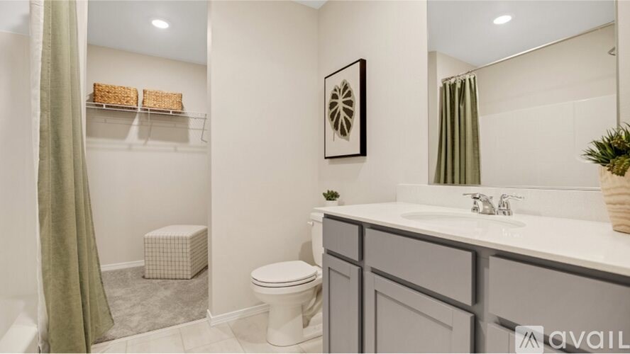 A bathroom with a toilet, sink, and a mirror.