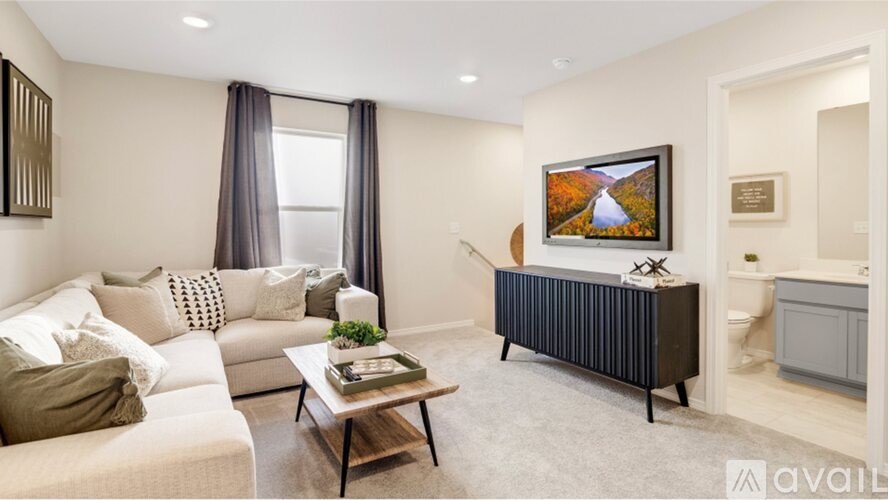 A living room with a couch, a coffee table, and a painting on the wall.