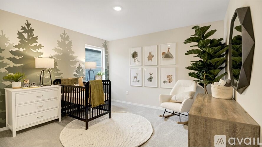 A baby's room with a crib, a chair, and pictures on the wall.