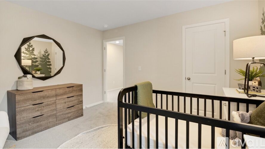 A baby's room with a crib, a dresser with a mirror, and a lamp.