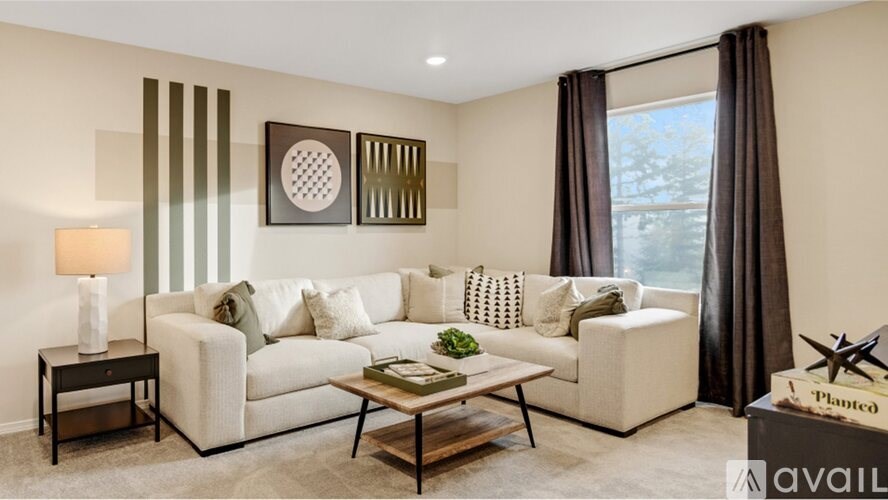 A living room with a white sofa, a coffee table, and a lamp on a side table.