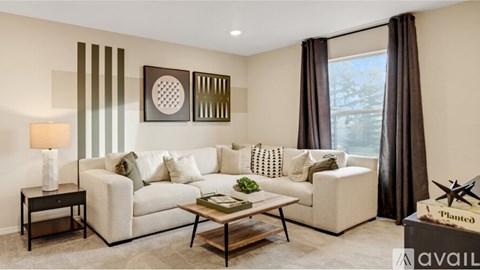 A living room with a white sofa, a coffee table, and a lamp on a side table.