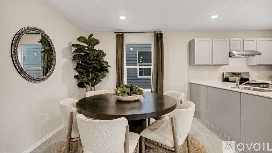 A modern dining room with a round table and chairs.
