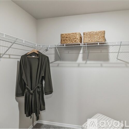 A grey coat hanging on a hanger in a white closet.