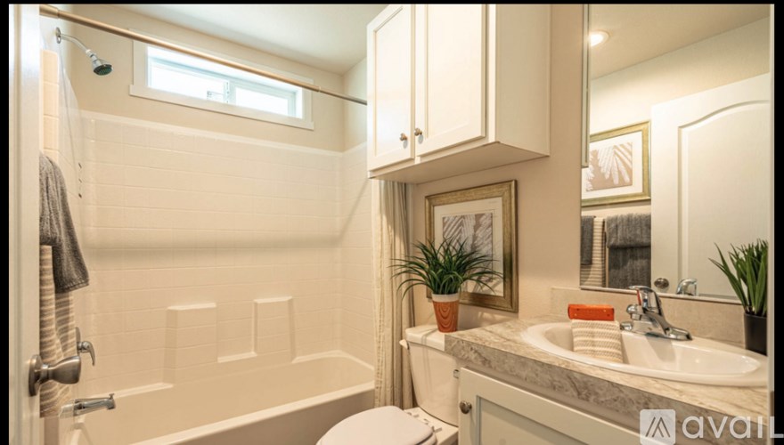 A bathroom with a white tub, sink, and toilet.