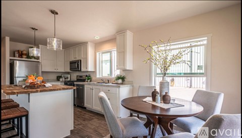 A modern kitchen with a dining table set for four.