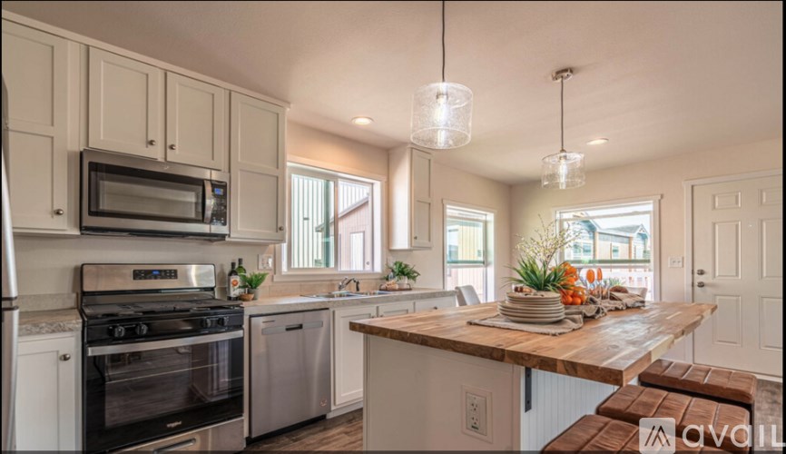 A kitchen with a wooden island and stainless steel appliances.