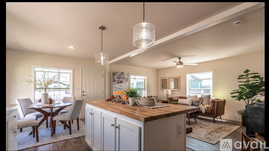 A well-lit kitchen and dining area with a wooden countertop and chairs.