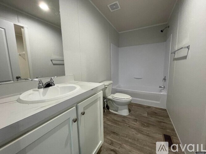 A bathroom with a sink, toilet, and bathtub.