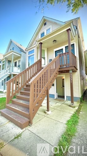 A two-story house with a wooden staircase leading to the second floor.